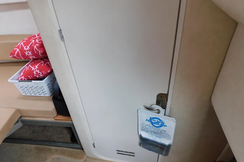 Slide: The Image of Interior of 2010 Sea Ray Sundancer 260 with red pillows and storage basket. - 69