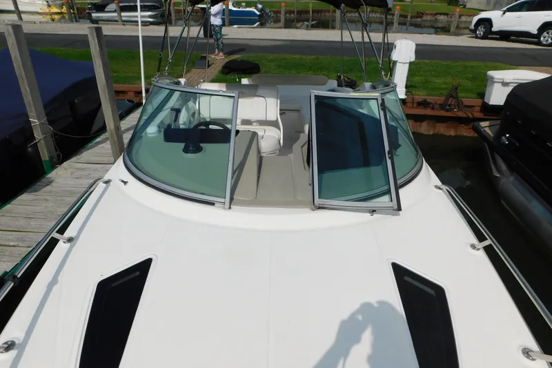 Slide: The Image of 2010 Sea Ray Sundancer 260 boat docked, featuring open windshield and sleek design. - 40