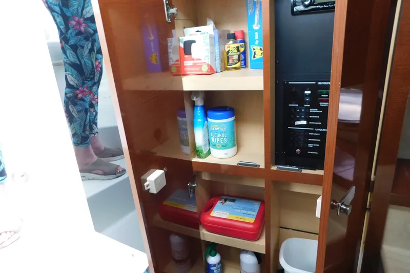 Slide: The Image of Cabinet storage inside a 2010 Sea Ray Sundancer 260 boat, featuring cleaning supplies and electrical panel. - 67