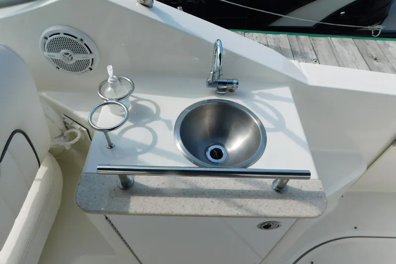 Slide: The Image of Cockpit sink area on 2010 Sea Ray Sundancer 260 boat with faucet and cup holders. - 19
