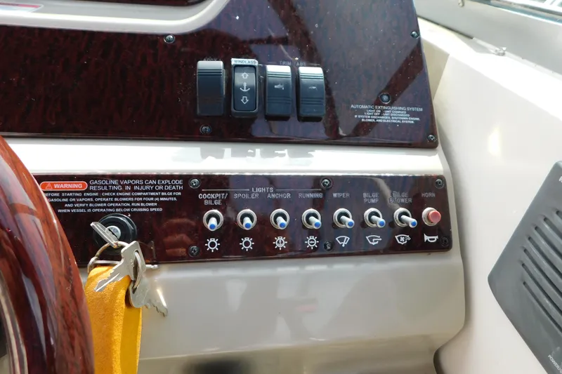 Slide: The Image of Control panel of a 2010 Sea Ray Sundancer 260 boat with various switches and warning labels. - 35