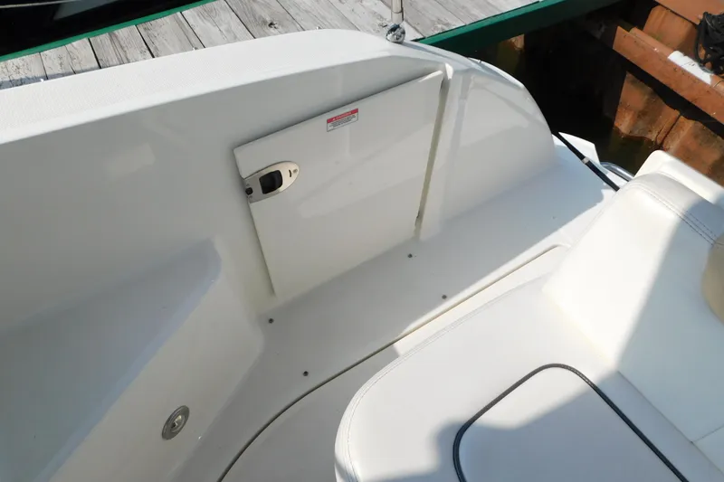 Slide: The Image of 2010 Sea Ray Sundancer 260 boat interior with white seating and storage compartment. - 16