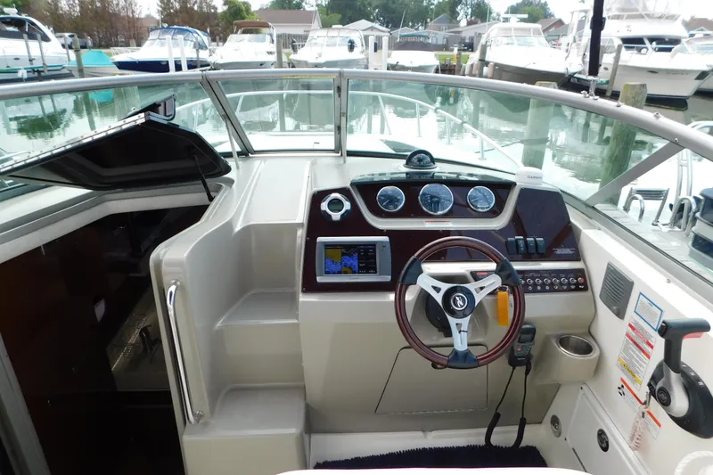 Slide: The Image of 2010 Sea Ray Sundancer 260 cockpit with steering wheel and navigation instruments. - 26