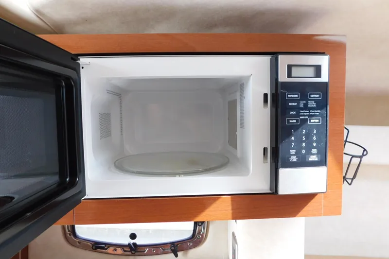 Slide: The Image of Microwave inside 2010 Sea Ray Sundancer 260 boat, featuring digital controls and open door. - 59