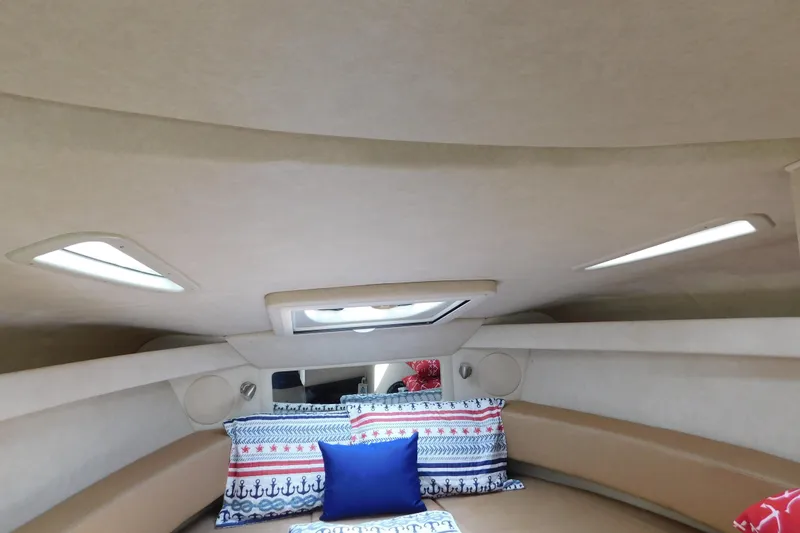 Slide: The Image of Interior cabin of 2010 Sea Ray Sundancer 260 with nautical-themed pillows and skylight. - 51