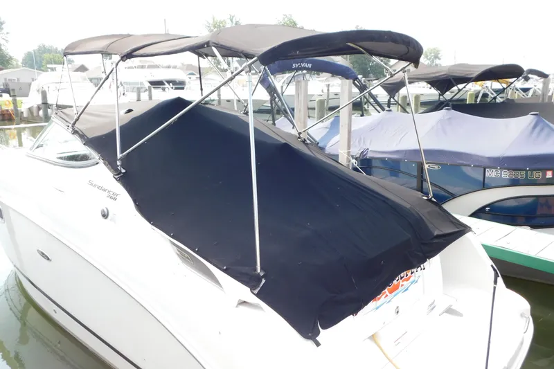 Slide: The Image of 2010 Sea Ray Sundancer 260 boat with black canopy docked at marina. - 4