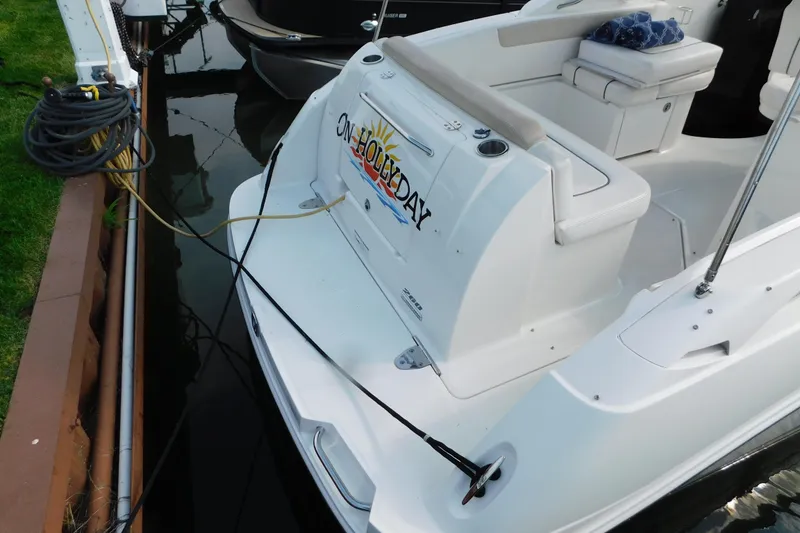 Slide: The Image of 2010 Sea Ray Sundancer 260 docked, featuring comfortable seating and "On Holiday" decal. - 7