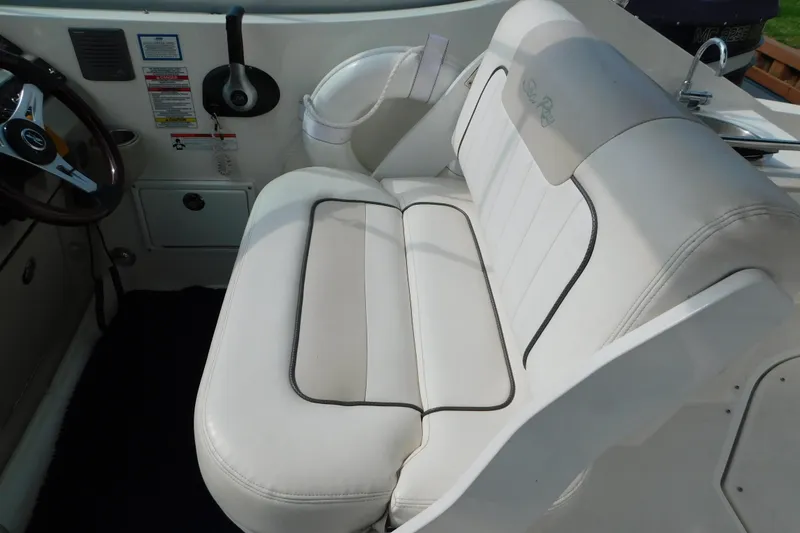 Slide: The Image of 2010 Sea Ray Sundancer 260 interior with white seating and steering wheel. - 31