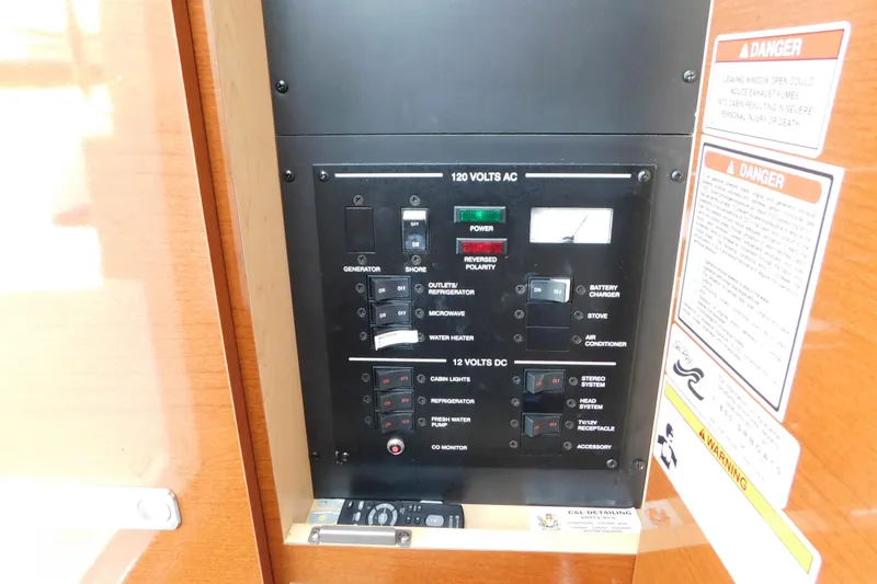 Slide: The Image of Electrical control panel on a 2010 Sea Ray Sundancer 260 boat, featuring various switches and warnings. - 66