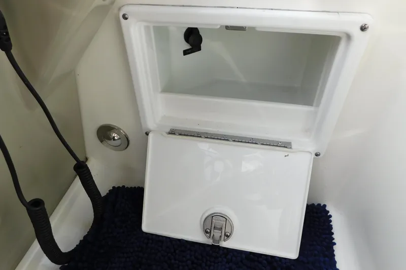 Slide: The Image of Storage compartment on a 2010 Sea Ray Sundancer 260 boat, featuring a secure latch. - 33