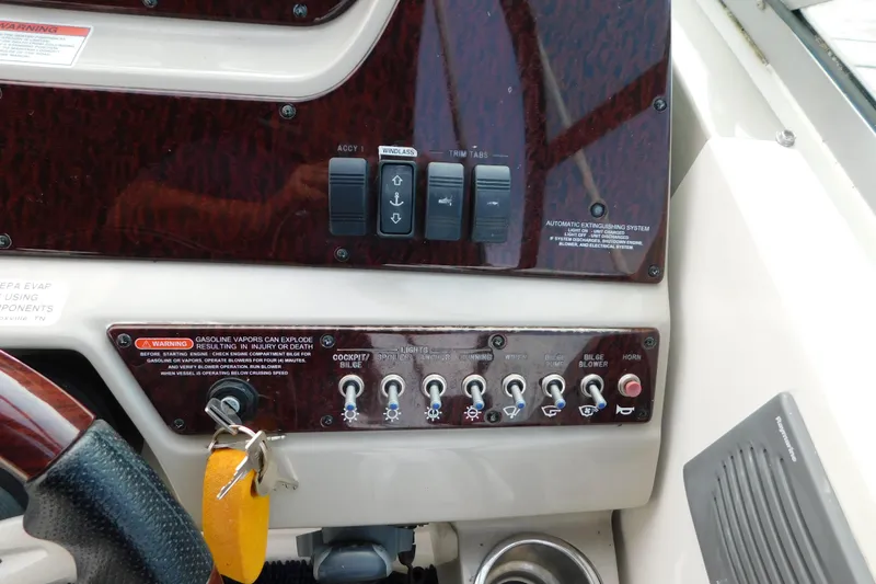 Slide: The Image of Control panel of a 2010 Sea Ray Sundancer 260 boat with switches and warning labels. - 23