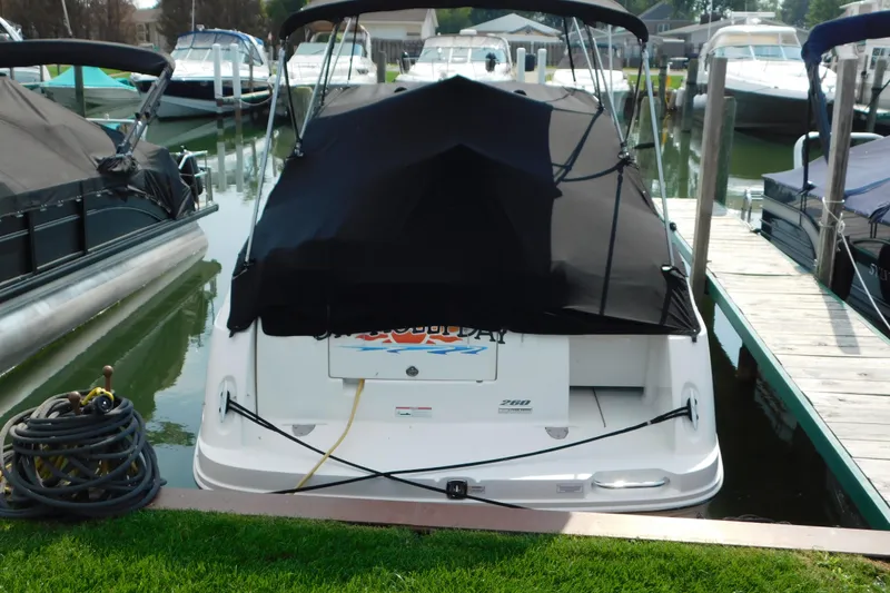 Slide: The Image of 2010 Sea Ray Sundancer 260 docked at marina with black cover. - 2