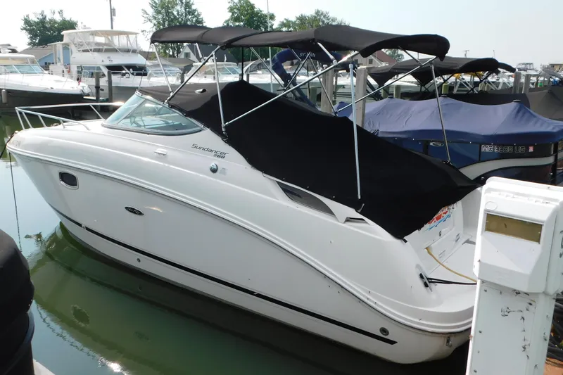The Image of 2010 Sea Ray Sundancer 260 boat docked in marina with black canopy. - 0