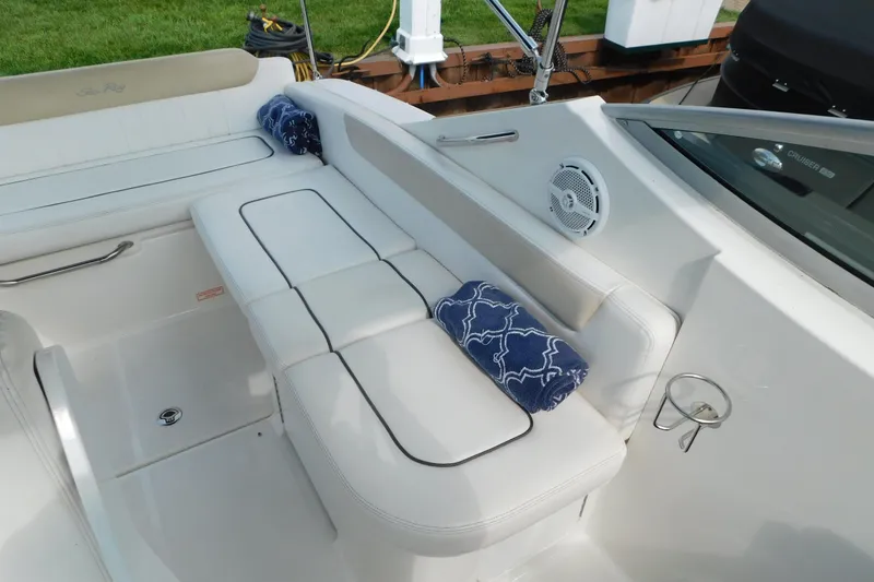 Slide: The Image of 2010 Sea Ray Sundancer 260 boat interior with white seating and blue towels. - 29