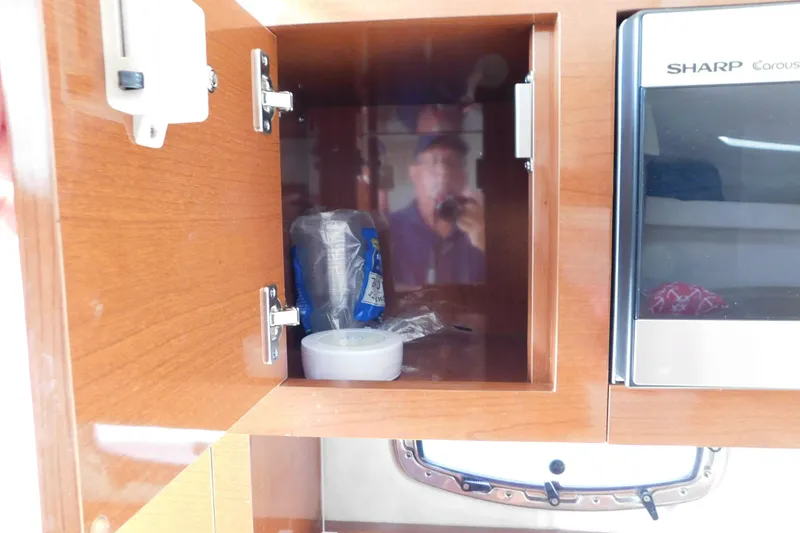 Slide: The Image of Open wooden cabinet in 2010 Sea Ray Sundancer 260 boat interior, next to microwave. - 60