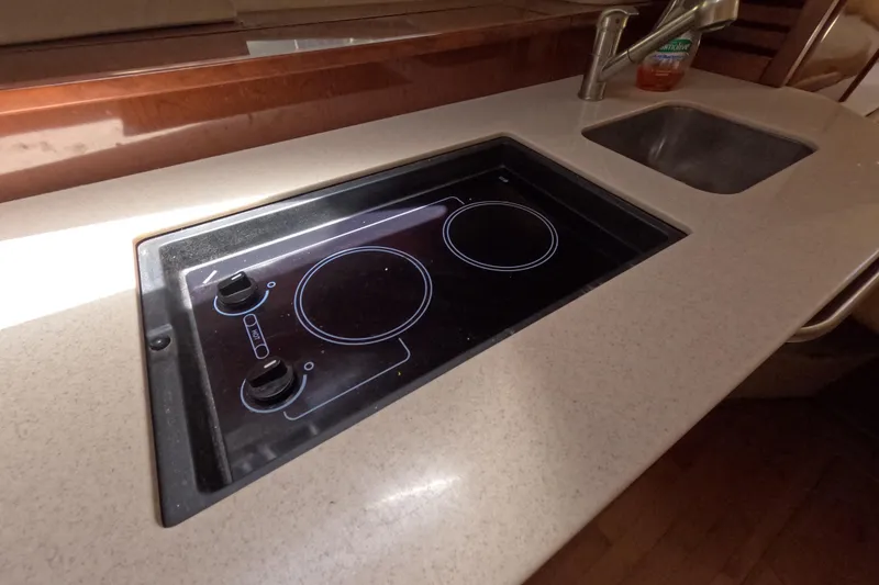 Slide: The Image of 2008 Sea Ray Sundancer 350 kitchen with stovetop and sink, featuring sleek countertop design. - 12
