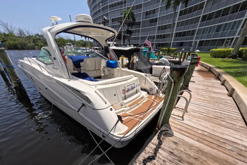 The Image of 2008 Sea Ray Sundancer 350 docked at marina, surrounded by water and greenery. - 0