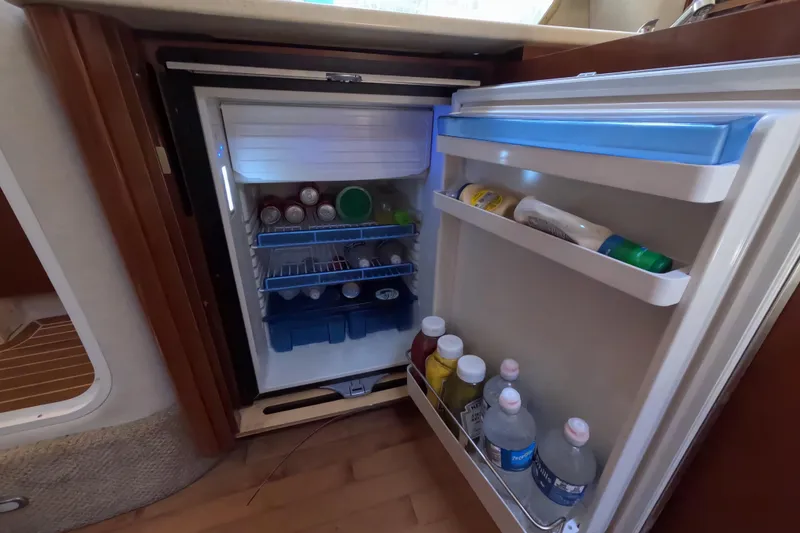 Slide: The Image of Mini fridge stocked with beverages and condiments inside a 2008 Sea Ray Sundancer 350 yacht. - 10