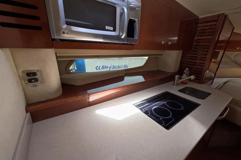 Slide: The Image of Interior of a 2008 Sea Ray Sundancer 350 yacht kitchen with stove, sink, and microwave. - 9