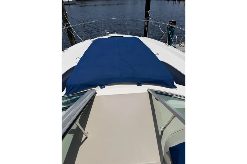Slide: The Image of 2008 Sea Ray Sundancer 350 boat deck with blue cover, docked by the water. - 31