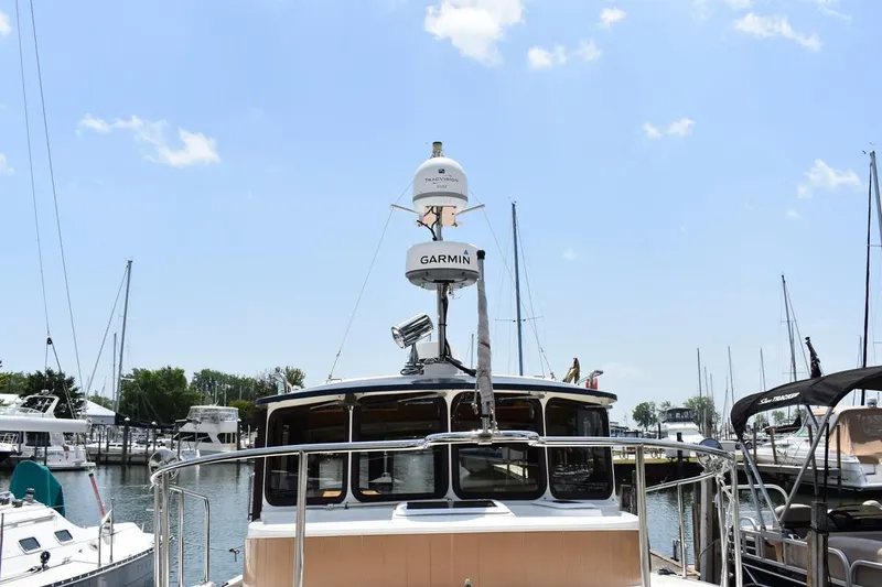 Slide: The Image of 2013 Ranger Tugs R-29 boat docked at marina, featuring Garmin equipment under clear blue sky. - 9