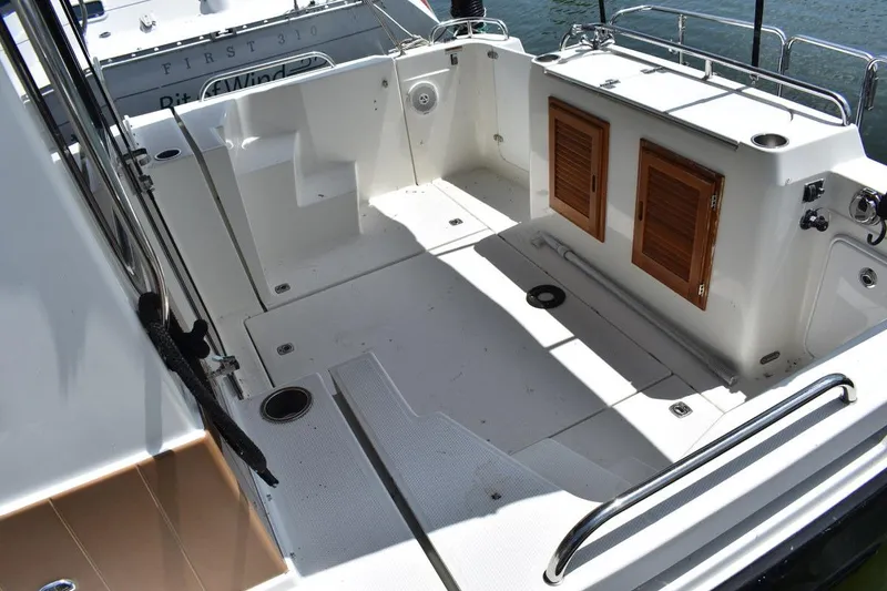 Slide: The Image of 2013 Ranger Tugs R-29 boat deck with wooden storage compartments and railing. - 11