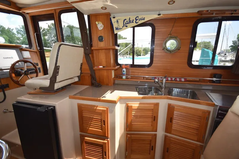Slide: The Image of Interior of 2013 Ranger Tugs R-29 boat with helm, kitchen, and wooden cabinetry. - 23