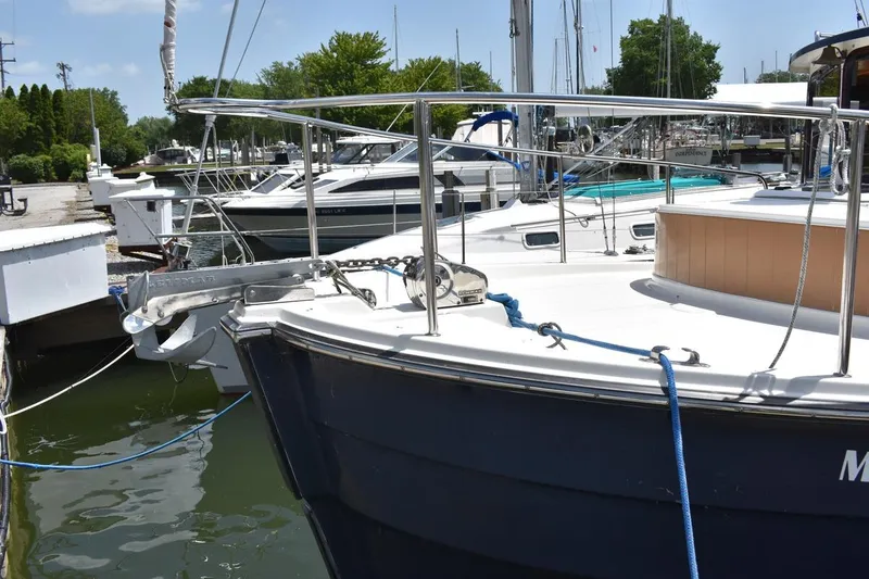 Slide: The Image of 2013 Ranger Tugs R-29 docked at marina, featuring anchor and railing. - 3