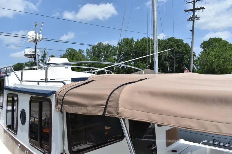 Slide: The Image of 2013 Ranger Tugs R-29 boat with beige canopy, docked under clear blue sky. - 10