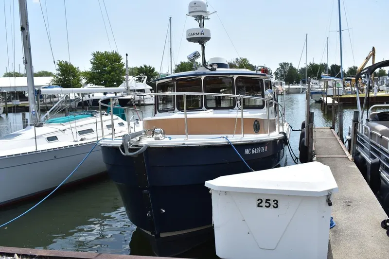 Slide: The Image of 2013 Ranger Tugs R-29 docked at a marina, surrounded by other boats. - 6