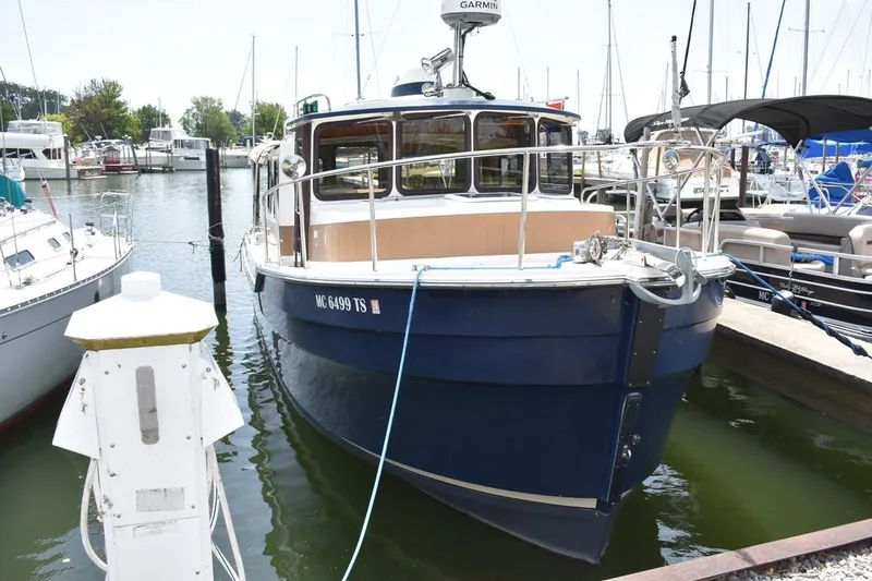Slide: The Image of 2013 Ranger Tugs R-29 boat docked in a marina, surrounded by other vessels. - 5