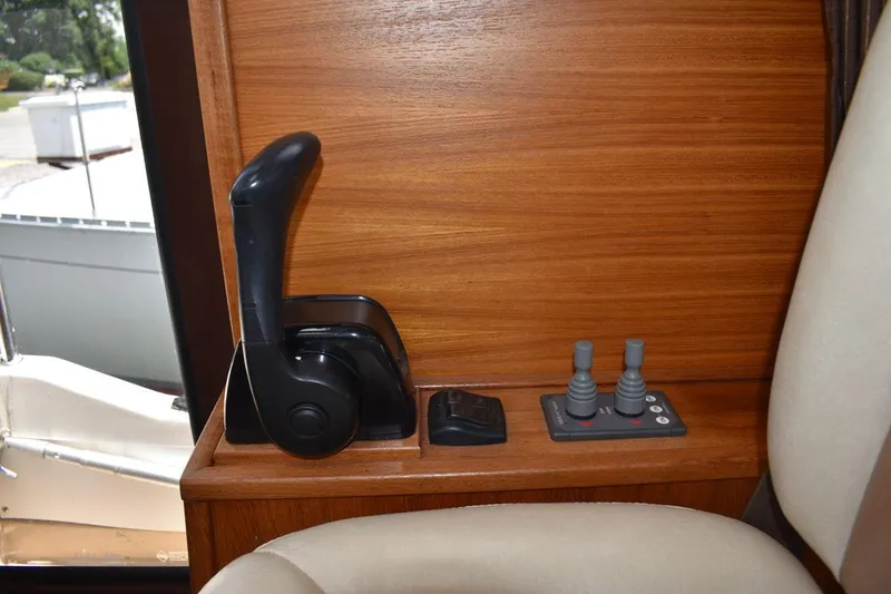 Slide: The Image of 2013 Ranger Tugs R-29 interior controls with wooden paneling and joystick levers. - 33