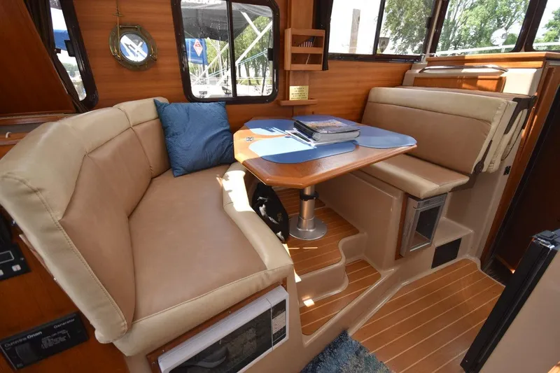 Slide: The Image of Interior of 2013 Ranger Tugs R-29 with cozy seating and wooden table. - 20