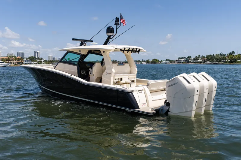 Slide: The Image of 2024 Scout 425 LXF boat with triple Mercury engines on a sunny day. - 7