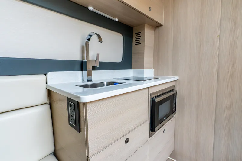 Slide: The Image of Modern kitchenette in 2024 Scout 425 LXF boat with sink, stove, and microwave. - 50