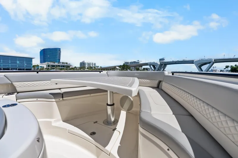 Slide: The Image of Luxurious seating area on 2024 Scout 425 LXF boat with cityscape and bridge in background. - 27