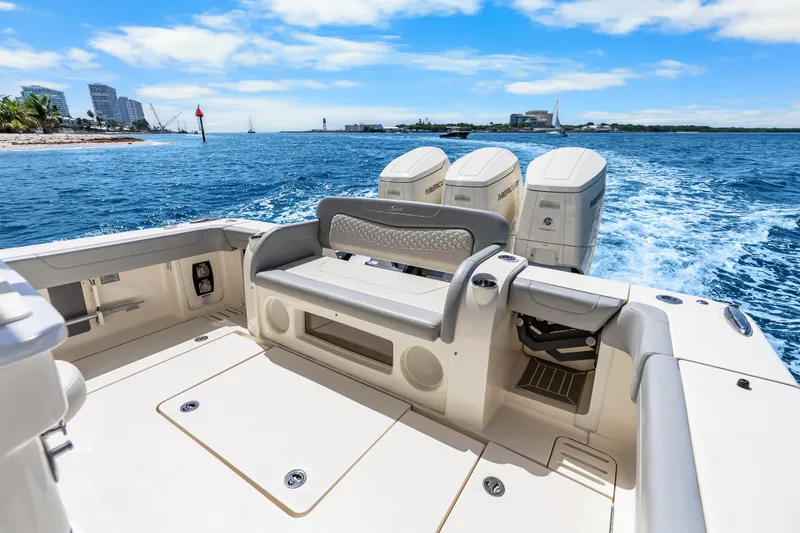 Slide: The Image of 2024 Scout 425 LXF boat cruising on blue ocean with triple outboard engines. - 24