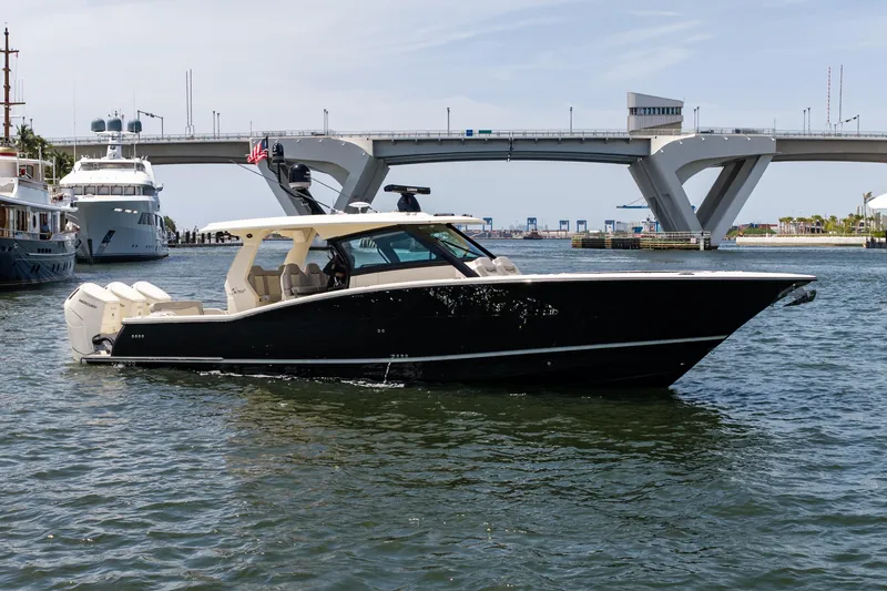 Slide: The Image of 2024 Scout 425 LXF boat cruising near a bridge in a marina setting. - 10