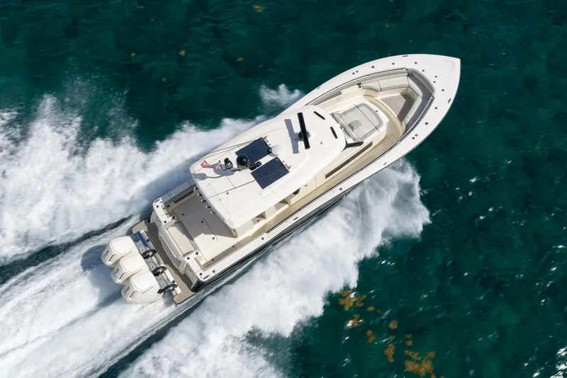 Slide: The Image of 2024 Scout 425 LXF boat cruising on clear blue water, aerial view. - 4