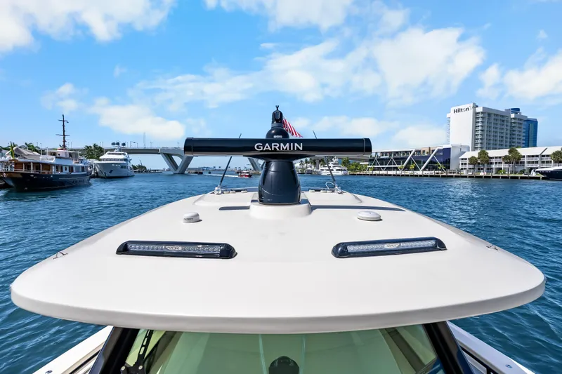Slide: The Image of 2024 Scout 425 LXF boat with Garmin radar on water, cityscape in background. - 31