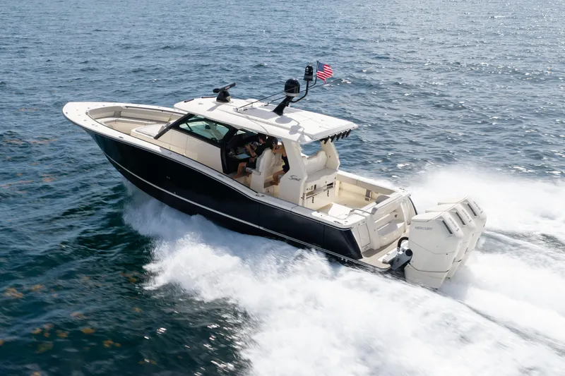 Slide: The Image of 2024 Scout 425 LXF boat cruising on open water with powerful engines. - 2