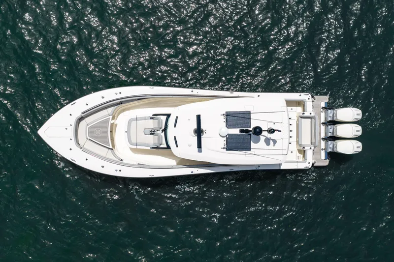 Slide: The Image of Overhead view of 2024 Scout 425 LXF boat on water, showcasing sleek design and triple engines. - 17