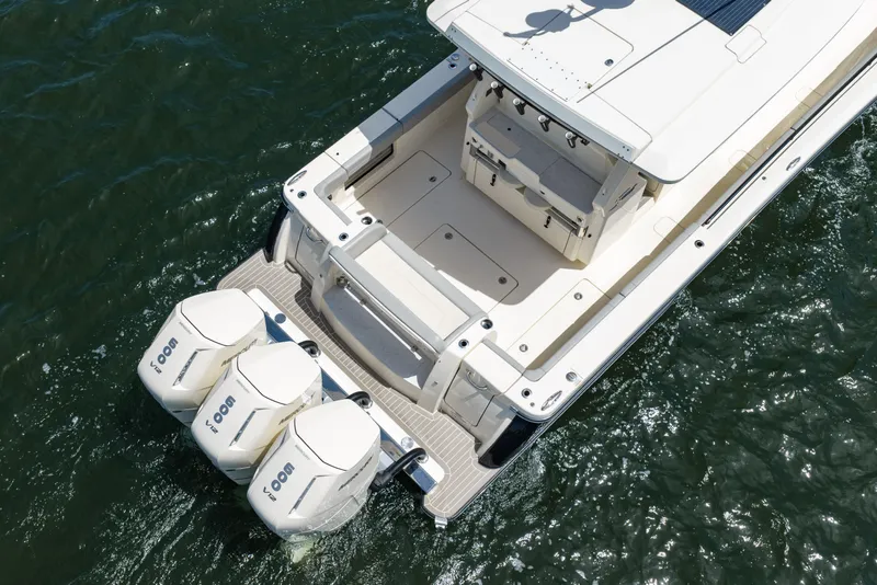 Slide: The Image of 2024 Scout 425 LXF boat with triple outboard engines on water. - 13