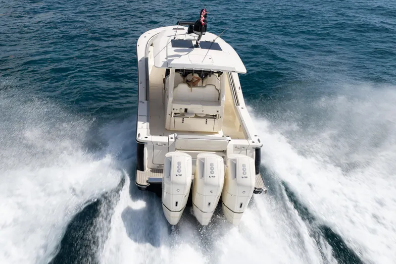Slide: The Image of 2024 Scout 425 LXF boat cruising on open water with triple outboard engines. - 3