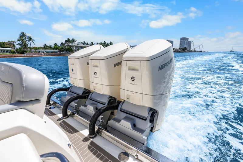 Slide: The Image of 2024 Scout 425 LXF boat with triple Mercury outboard engines cruising on blue water. - 23