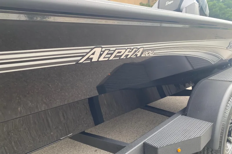 Slide: The Image of 2026 Ranger ALPHA 208 boat side view with sleek black finish and branding. - 2