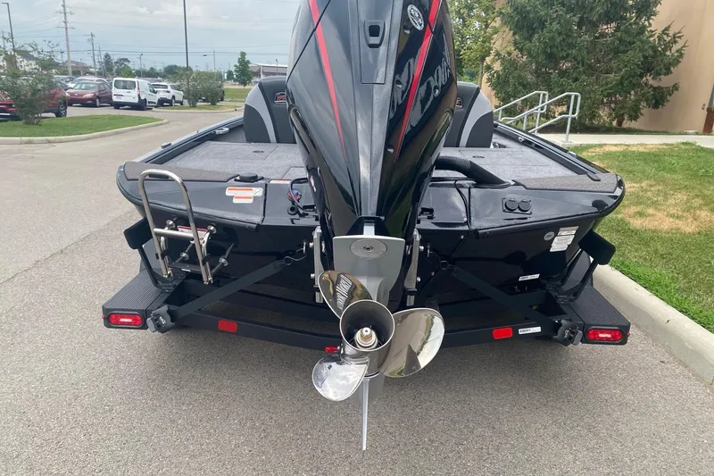 Slide: The Image of 2026 Ranger ALPHA 208 boat rear view with motor and trailer on pavement. - 8