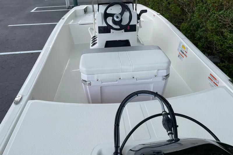 Slide: The Image of 2026 Mako Pro Skiff 15 CC boat interior with steering console and seating. - 13