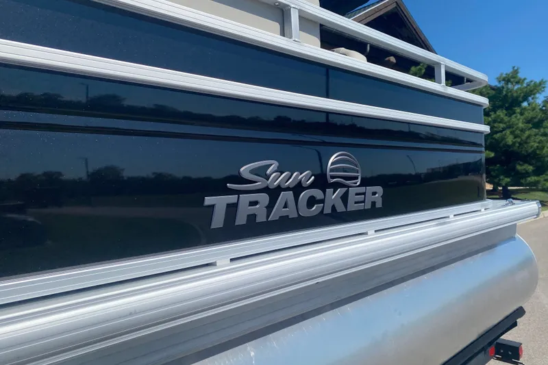 Slide: The Image of 2026 Sun Tracker Fishin' Barge 22 DLX pontoon boat, sleek black exterior with logo. - 2