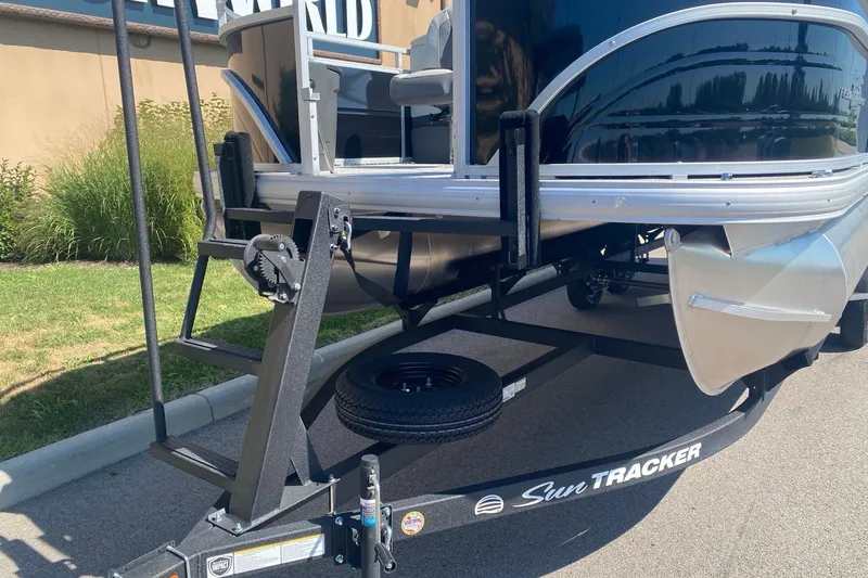 Slide: The Image of 2026 Sun Tracker Fishin' Barge 22 DLX on trailer, parked outdoors. - 3